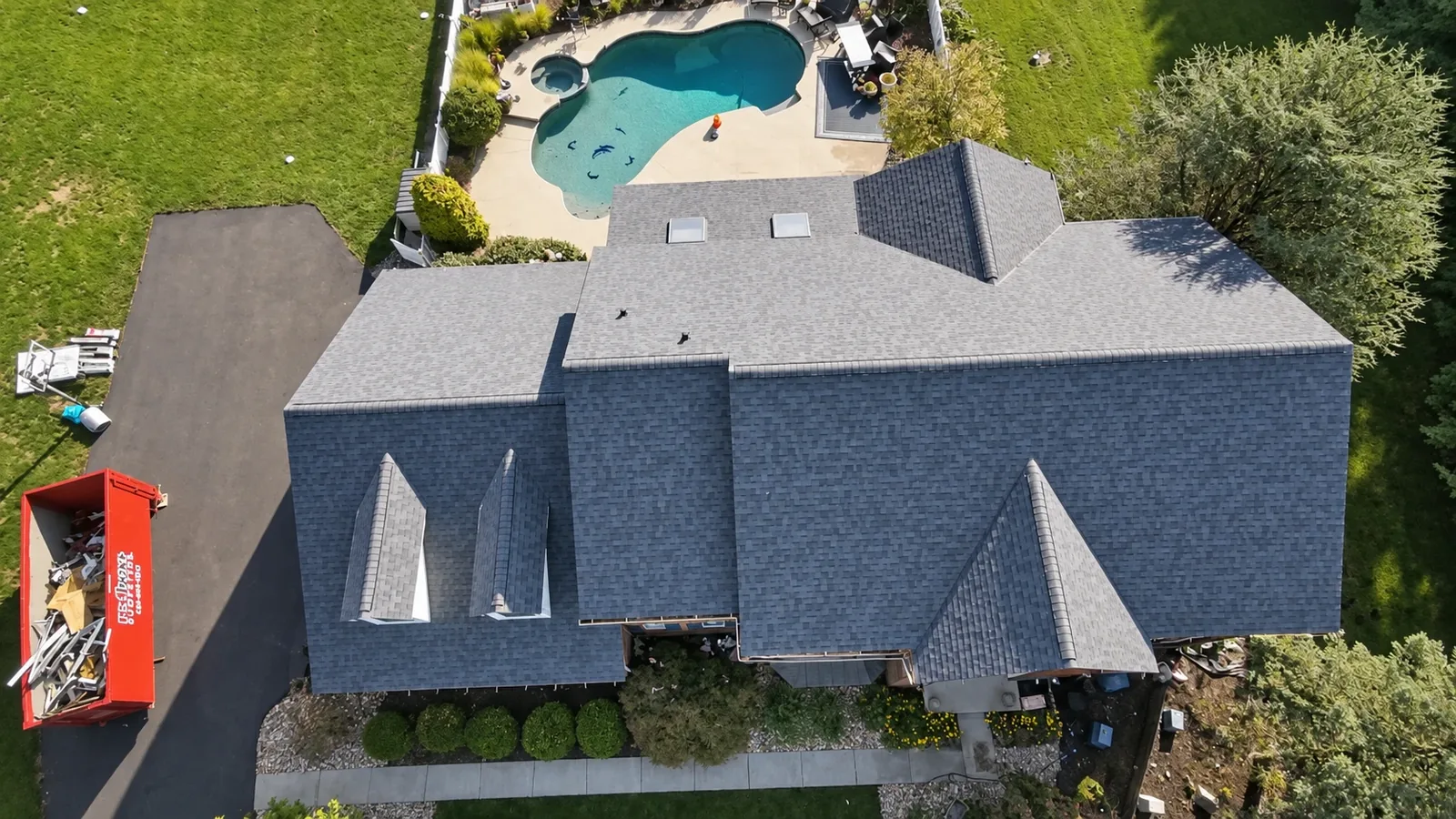 Overhead aerial of a completed Owens Corning Duration Harbor Blue roof with skylights on a poolside home in Nazareth, PA by LV Roofing & Siding