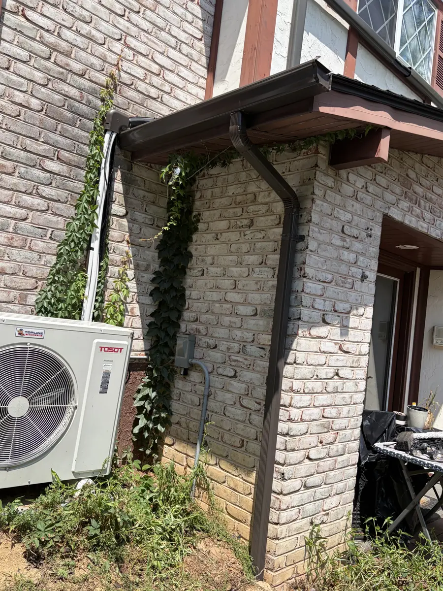New brown downspout and seamless gutter on a brick home by LV Roofing & Siding